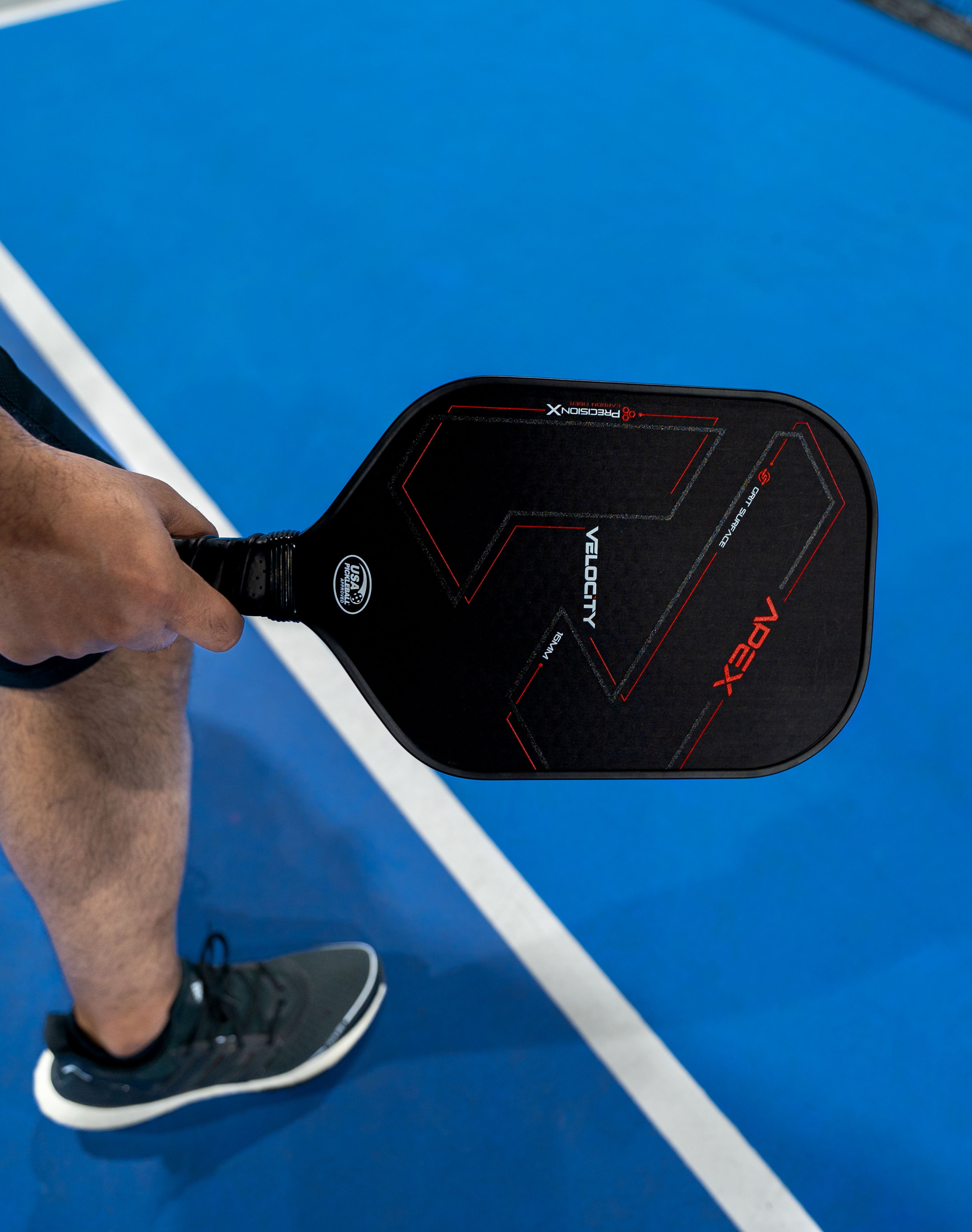 player holding apex carbon fiber paddle in hand